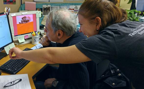 Man looking at a computer and a woman pointing at the screen