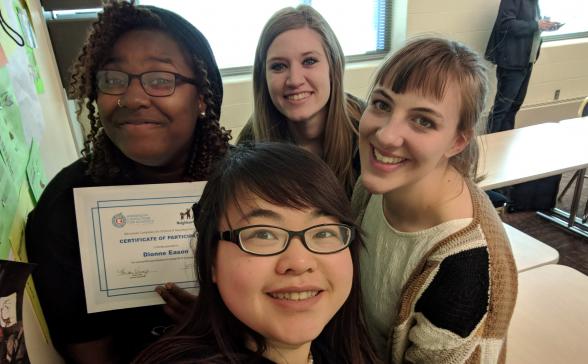 Woman holding a certificate with three other women