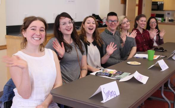 Panelists waving to the camera.