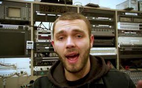 still shot of the video. A male in front of the control in SPNN's large studio