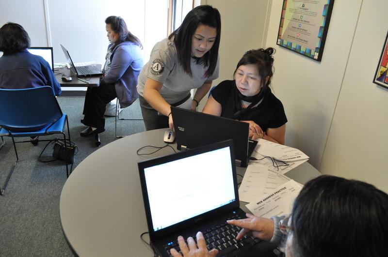 Woman helping elderly woman on the computer