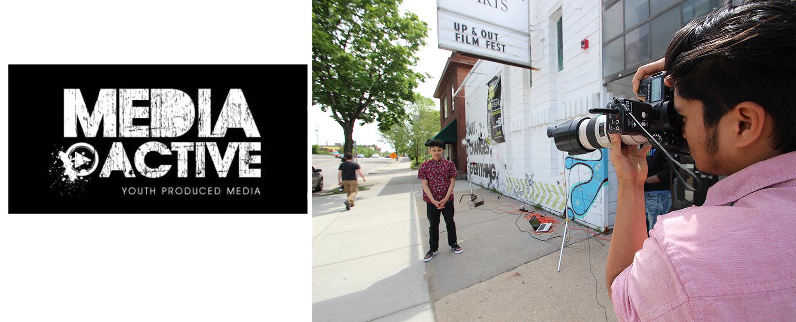 Left site black background with white text that says Media Active. Youth produced media. on the right a photo of a young person with a camera shooting another young person under a marquee that say up and out film festival.