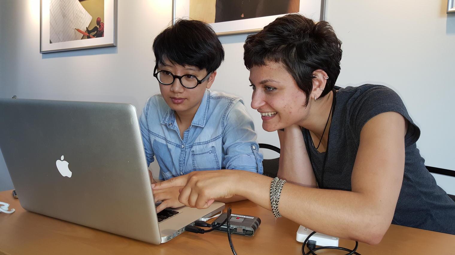 a photos of two women in front of a laptop.